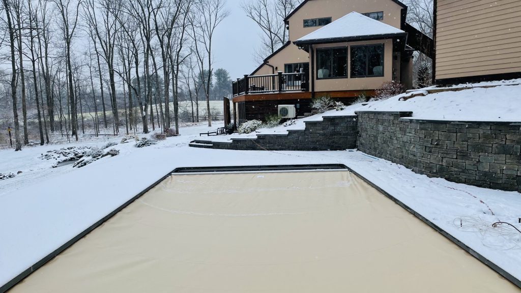 A house with a pool in the snow.